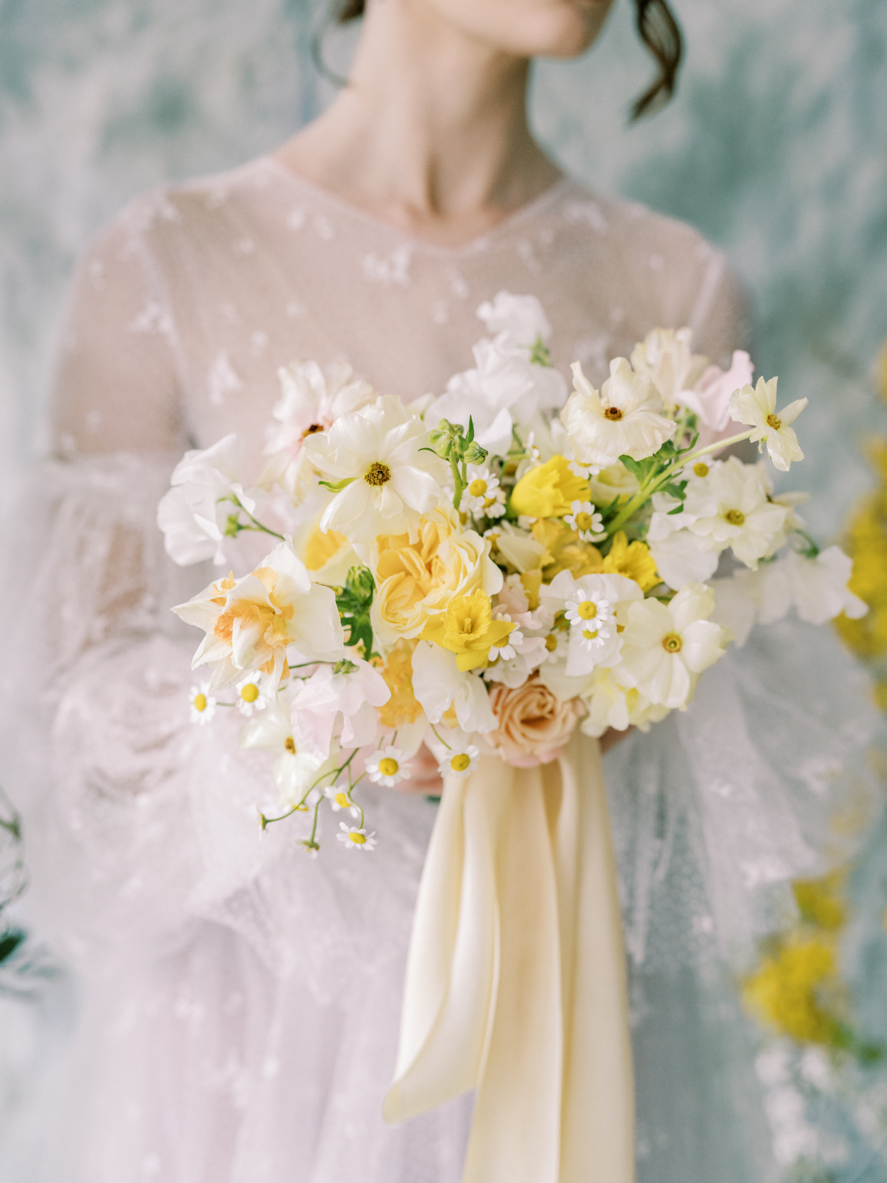 embroidered lace dress with soft yellow bouquet with roses and ranunculus silk and willow ribbon rooted in flora 
